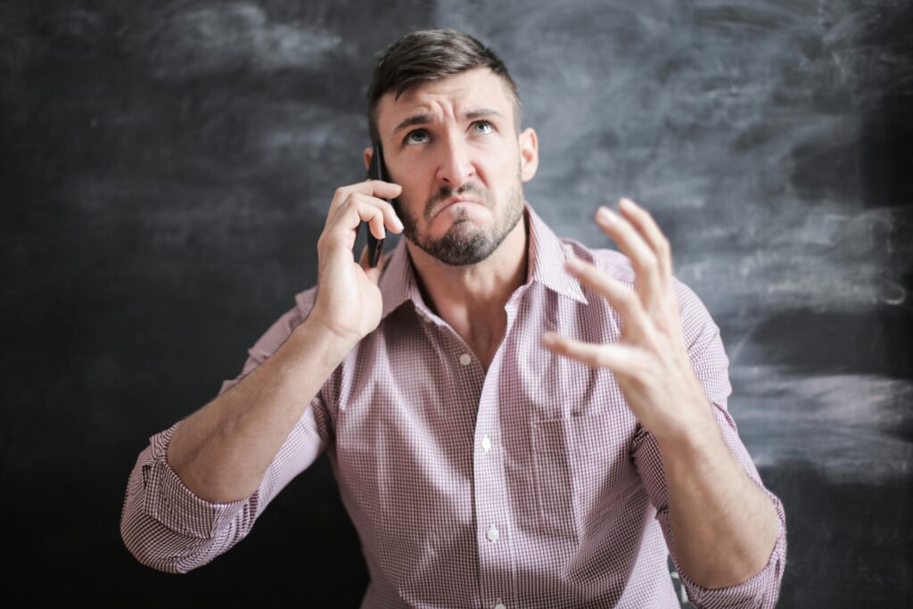 Man on the phone frustrated by ineffective fan rep